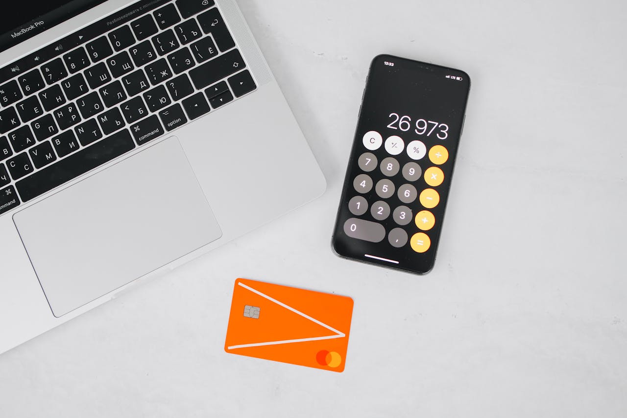 Crafting Captivating Headlines: Your awesome post title goes here A laptop, smartphone displaying calculator, and credit card on a white table.